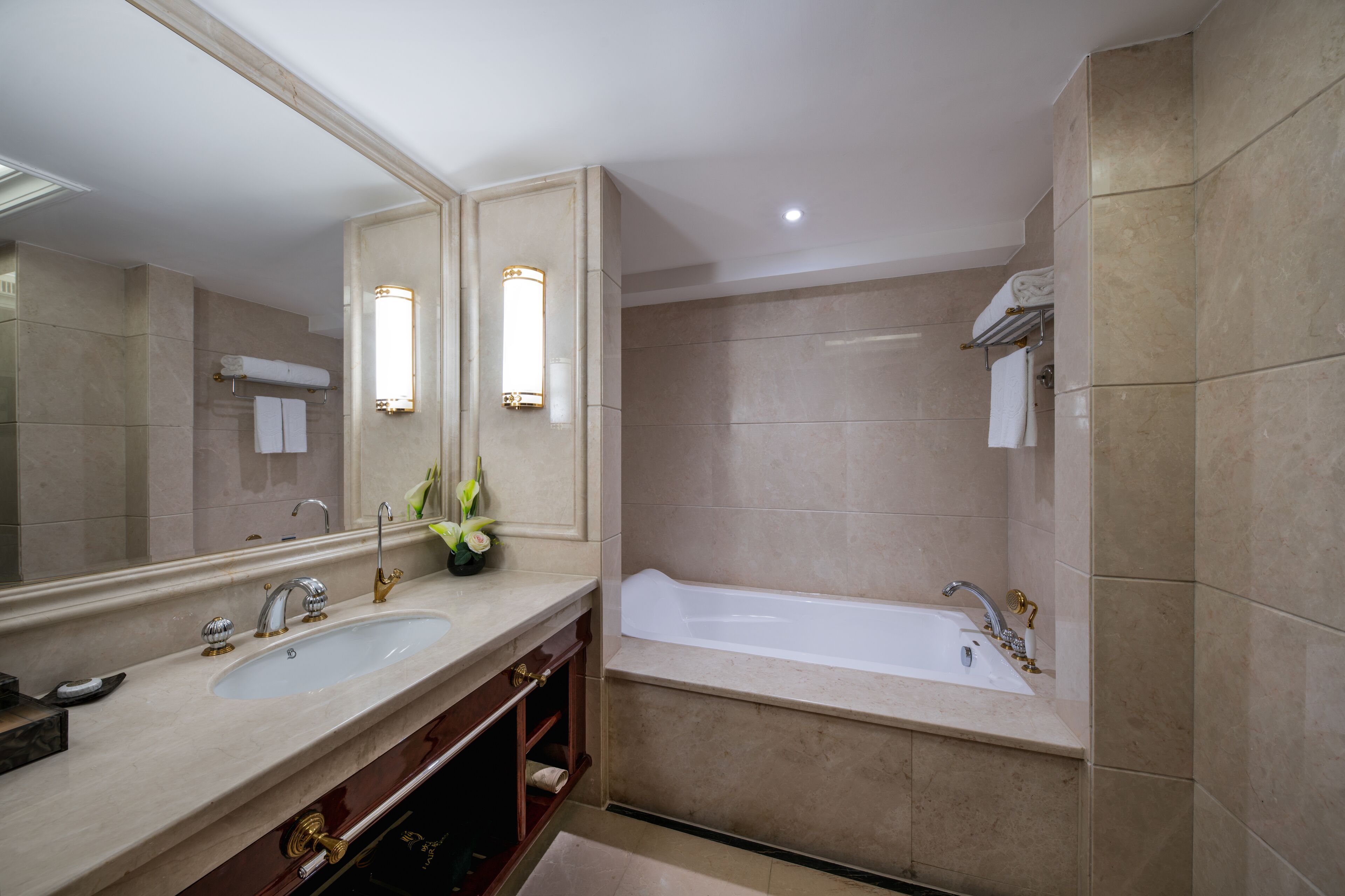 Un baño con dos lavamanos, una bañera y un espejo grande.
