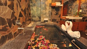 A stone-walled bathroom with a stone sink, a mirror, and towels. - The Privacy Beach Resort & Spa (Sam Roi Yot)