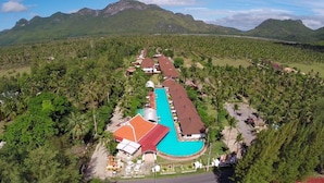 A resort with a swimming pool, surrounded by lush greenery and mountains. - The Privacy Beach Resort & Spa (Sam Roi Yot)