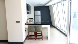 A modern kitchen with a black countertop, white cabinets, and a stainless steel refrigerator. - Yol Is Holiday Hotel Trabzon (Trabzon)