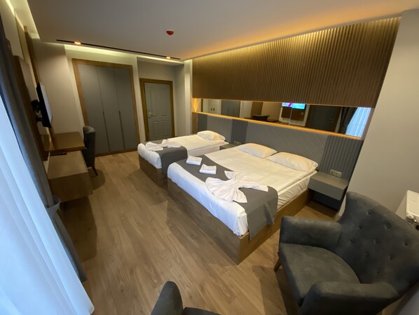 A hotel room with two beds, a desk, a chair, and a large mirror. - Sarikamis Aras Otel (Sarikamis)