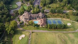 An aerial view of a golf course with a clubhouse, tennis courts, and a swimming pool. - Heavenly Hideaway 2 Bedroom Condo by RedAwning (Branson West)