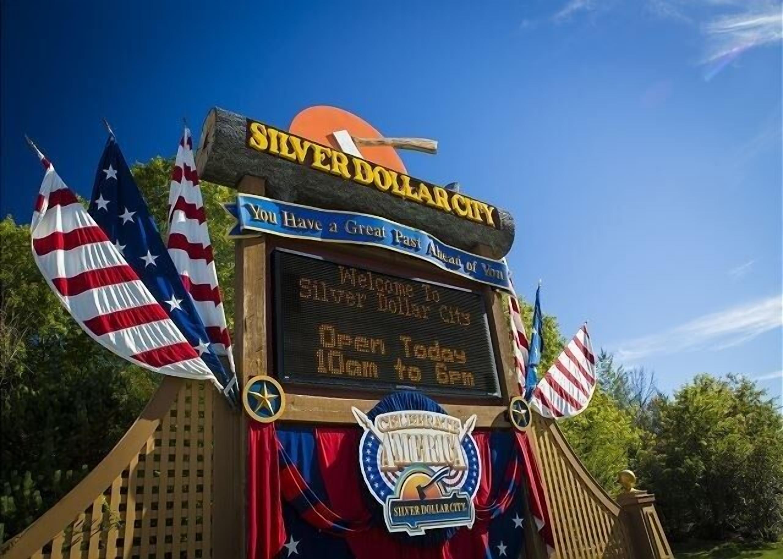 Placa de boas-vindas para Silver Dollar City com mensagem e horário de funcionamento.