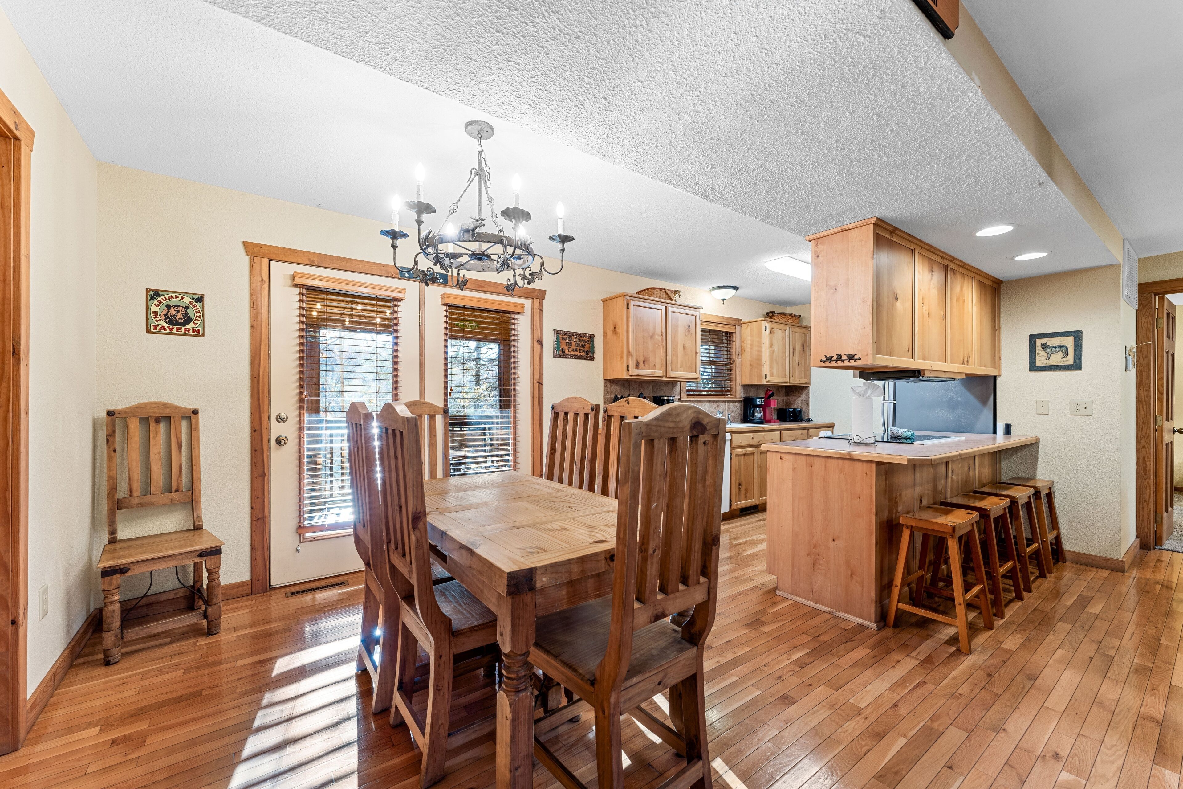 A spacious kitchen with wooden cabinets, a central island, and a dining area with a wooden table and chairs.