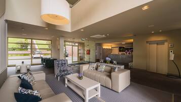 A modern lobby with a sofa, coffee table, and a reception desk.