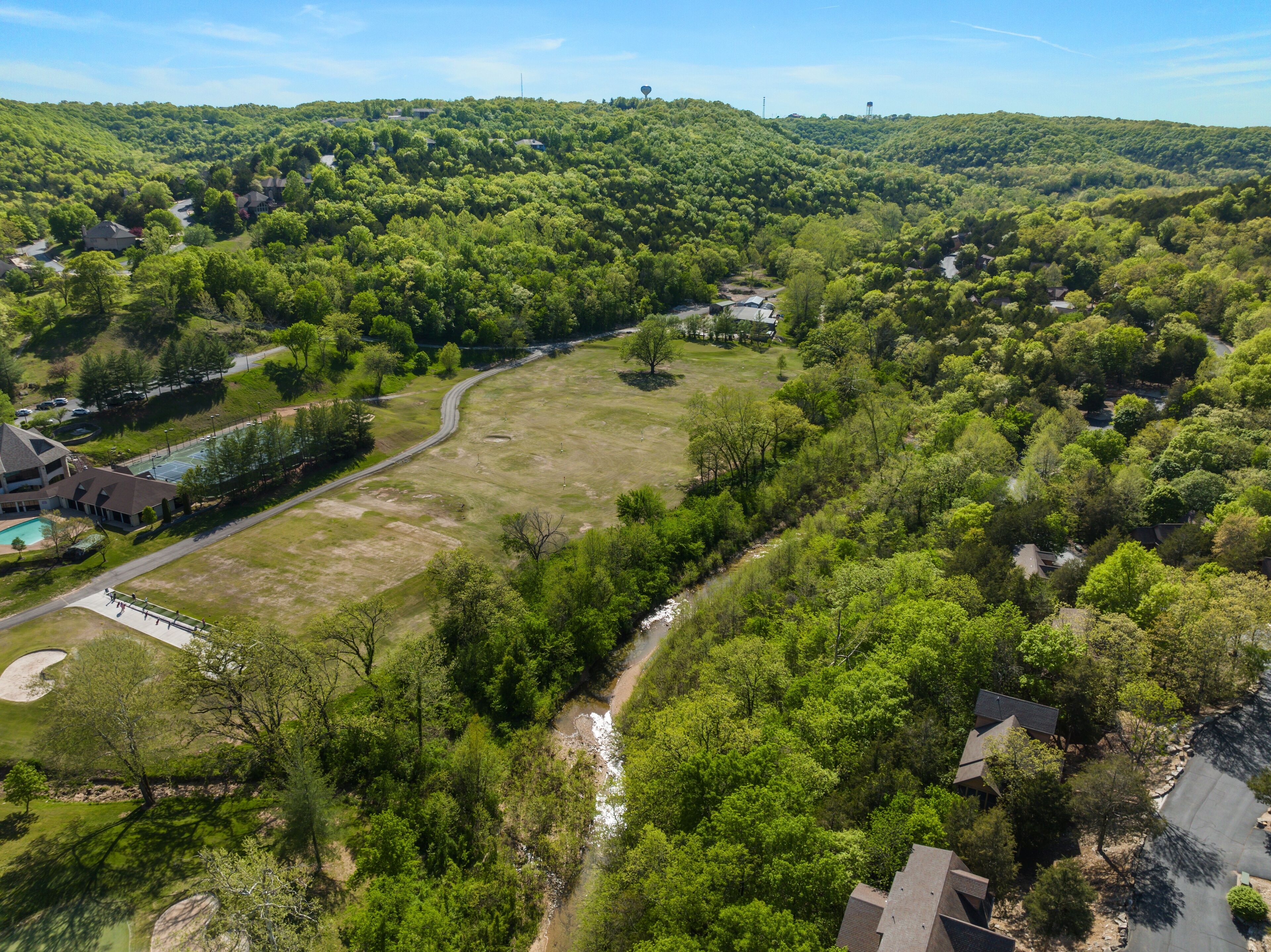 A residential area with houses, a swimming pool, and a golf course.