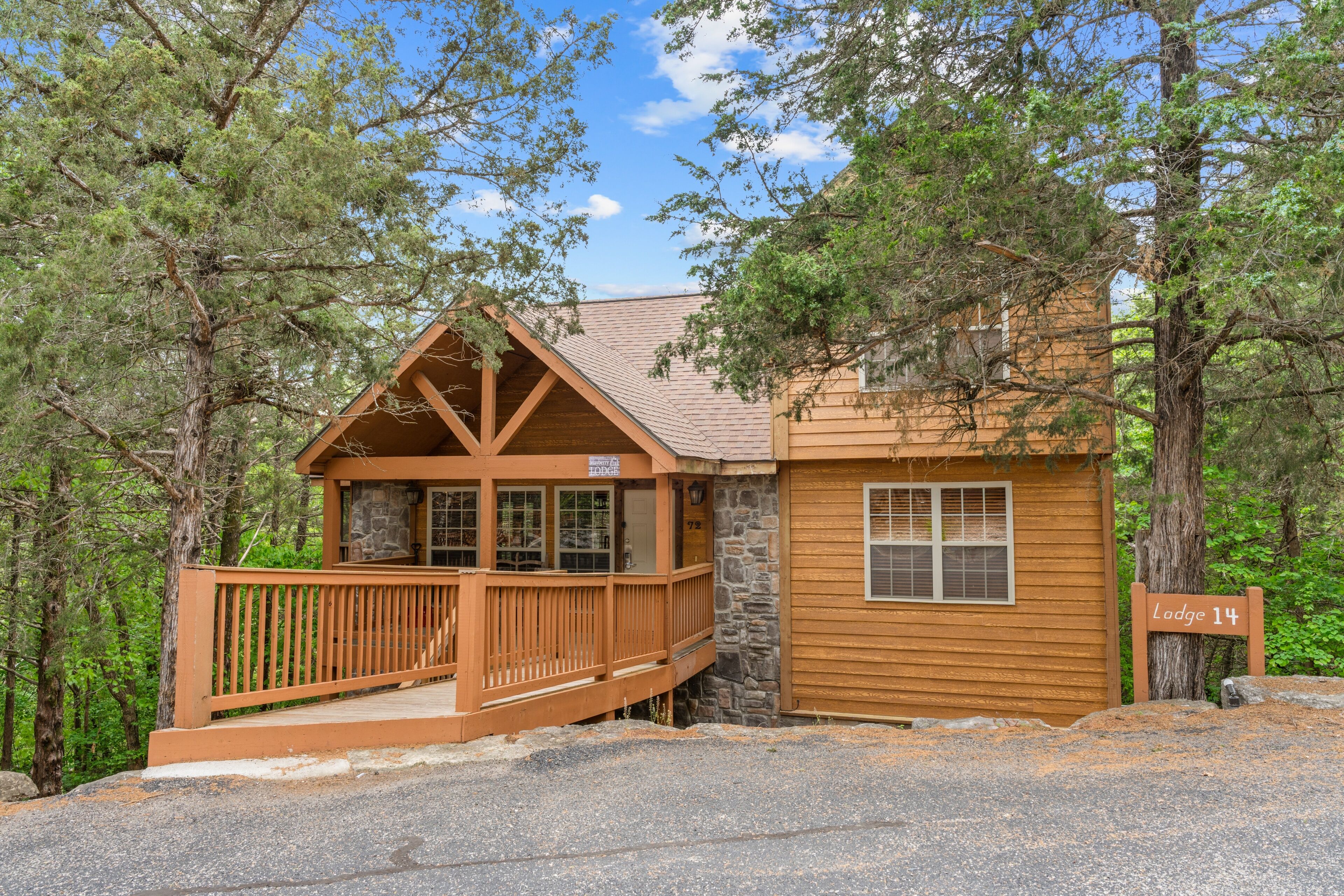 A lodge with a wooden exterior, stone foundation, and a wooden deck.