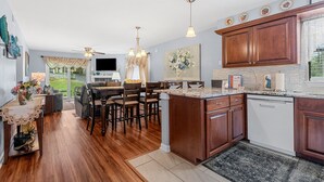 A modern kitchen with wooden cabinets, a granite countertop, and a built-in dishwasher.