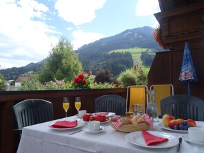 A table set for breakfast with a view of a mountainous landscape. - Apartment Anita (Westendorf)