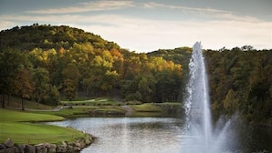 A serene landscape with a waterfall, a pond, and a golf course. - Dakota Lodge 2 Bedroom Home by RedAwning (Branson West)