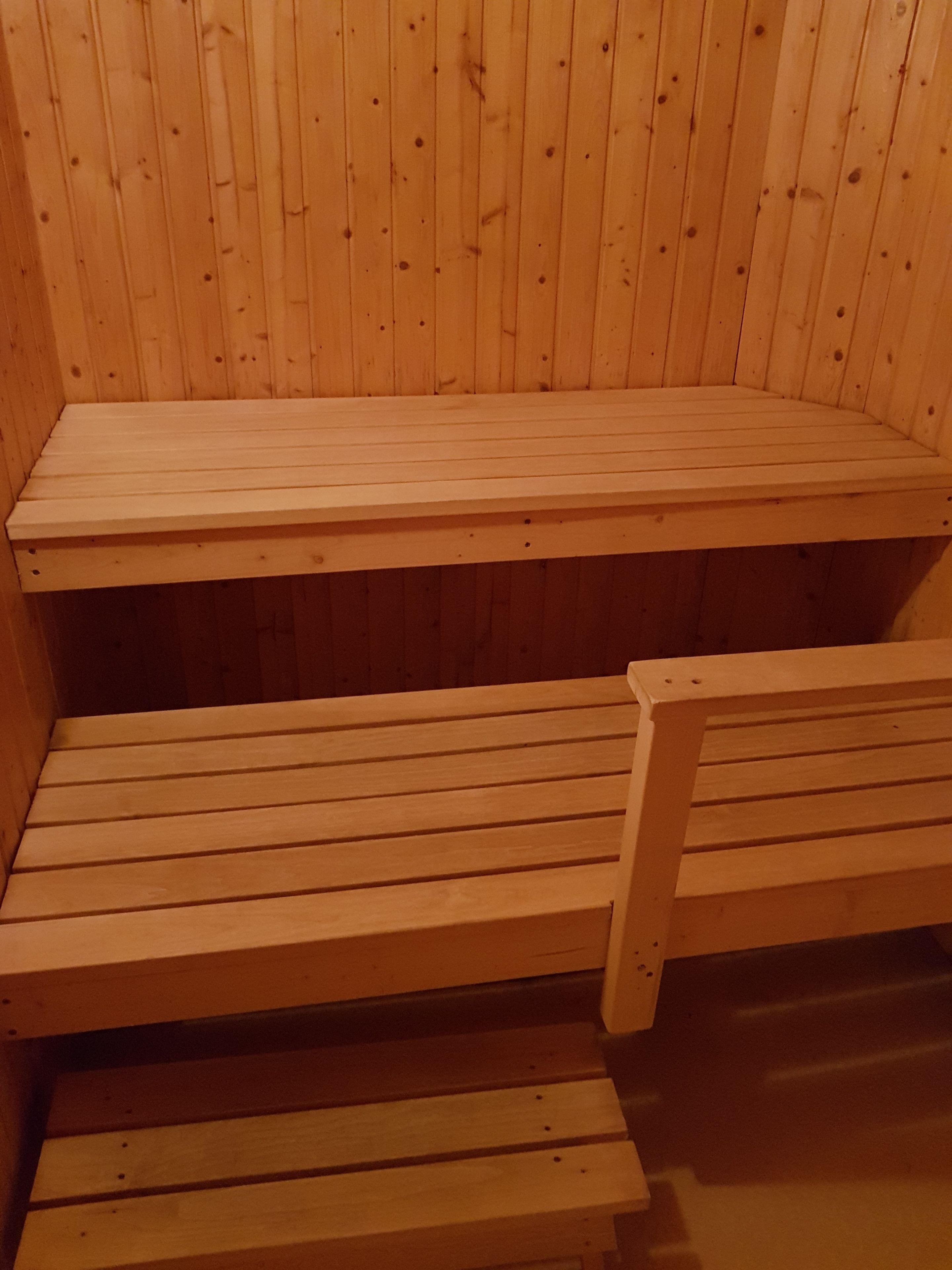 Eine Holzsauna mit Bänken und einer Sitzbank.