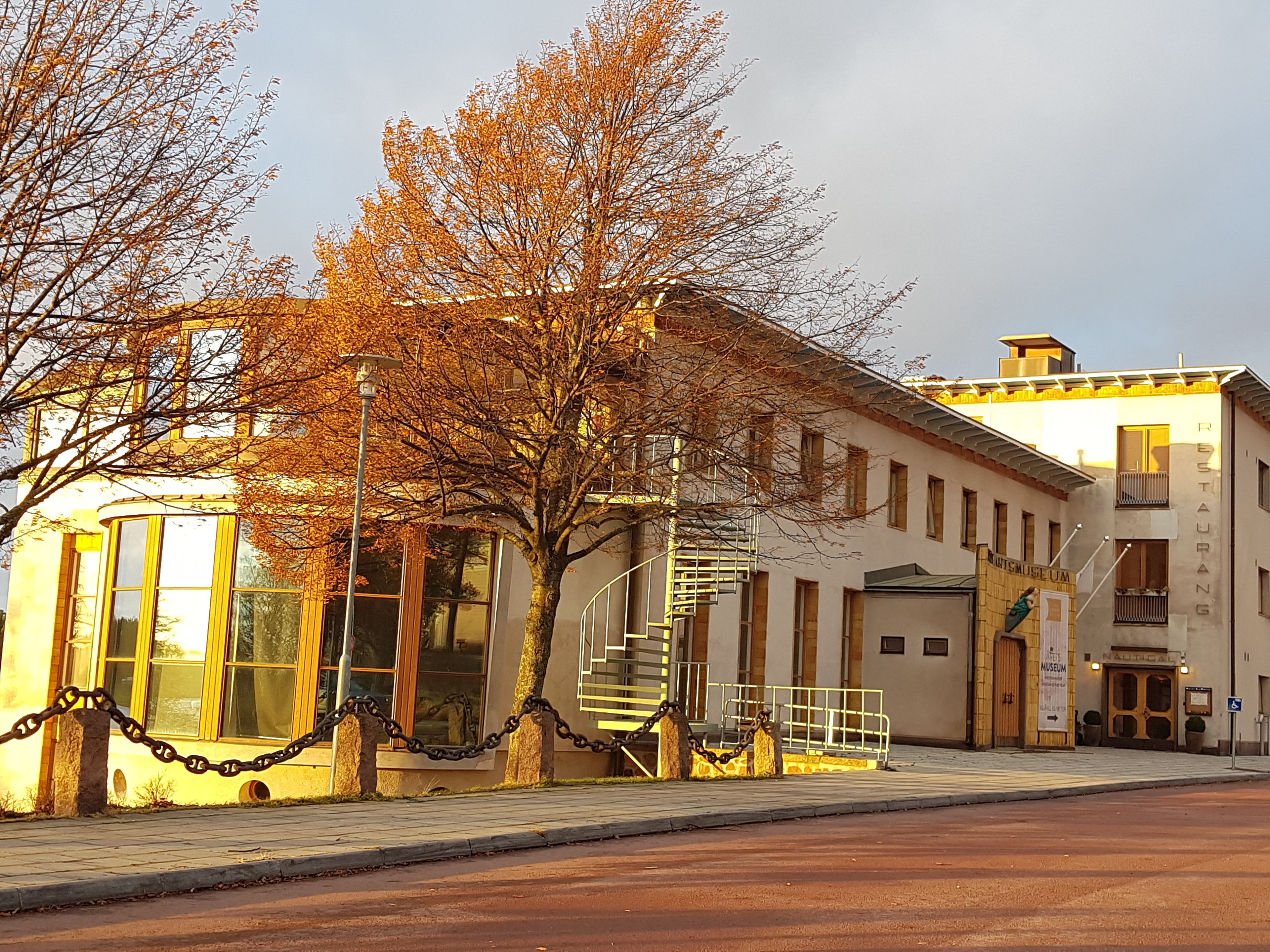 En bygning med trappe, hegn og et skilt for "ARTSMUSEUM".