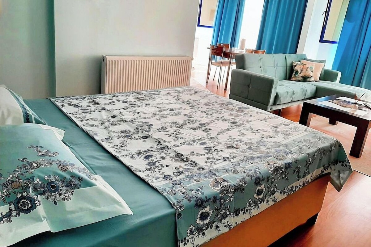 Una habitación de hotel con una cama, un sofá, una mesita y una silla.
