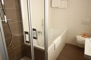 Apartamento luxo, 1 cama King, cozinha, vista para o pátio | Banheiro | Chuveiro com efeito de chuva, produtos de toalete grátis