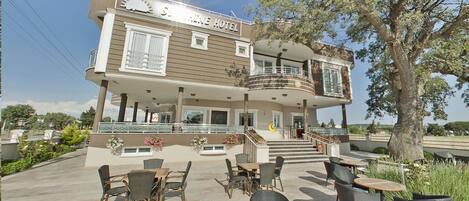 Sunshine Hotel with a two-story structure, outdoor seating area, and a staircase leading to the upper floor.