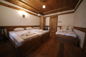 A wooden room with two beds, a wall-mounted light, and a door with a window. - Babahan Konaklari (Safranbolu)