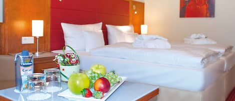 A hotel room with a bed, bedside tables, and a fruit plate.