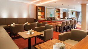 A modern bar area with seating and a bar counter. - Morada Hotel Heidesee Gifhorn (Gifhorn)