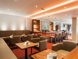 Zona de bar moderna con asientos y una barra.