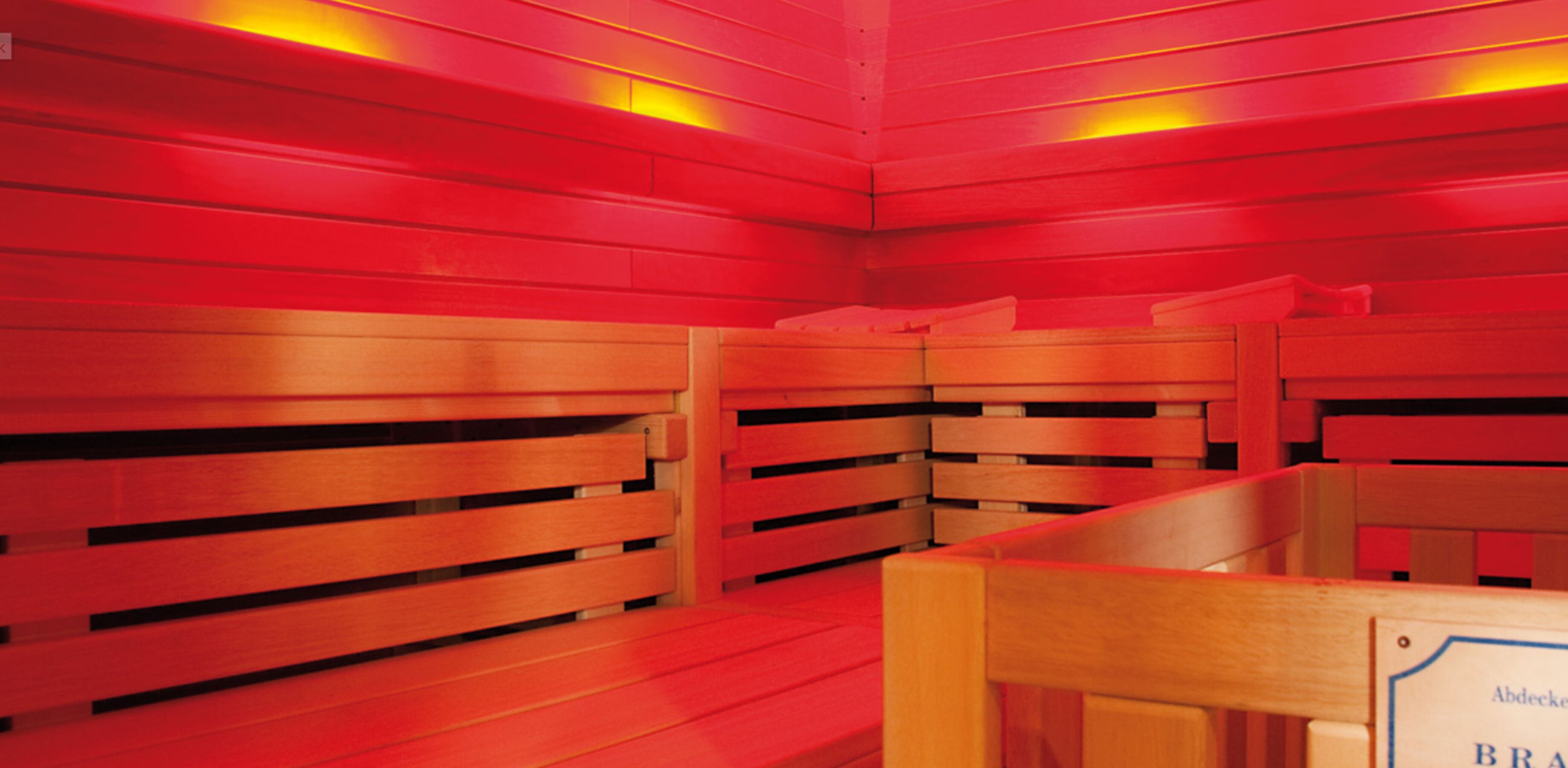 Un cuarto de sauna con bancos de madera y un cartel que indica que es una sauna.