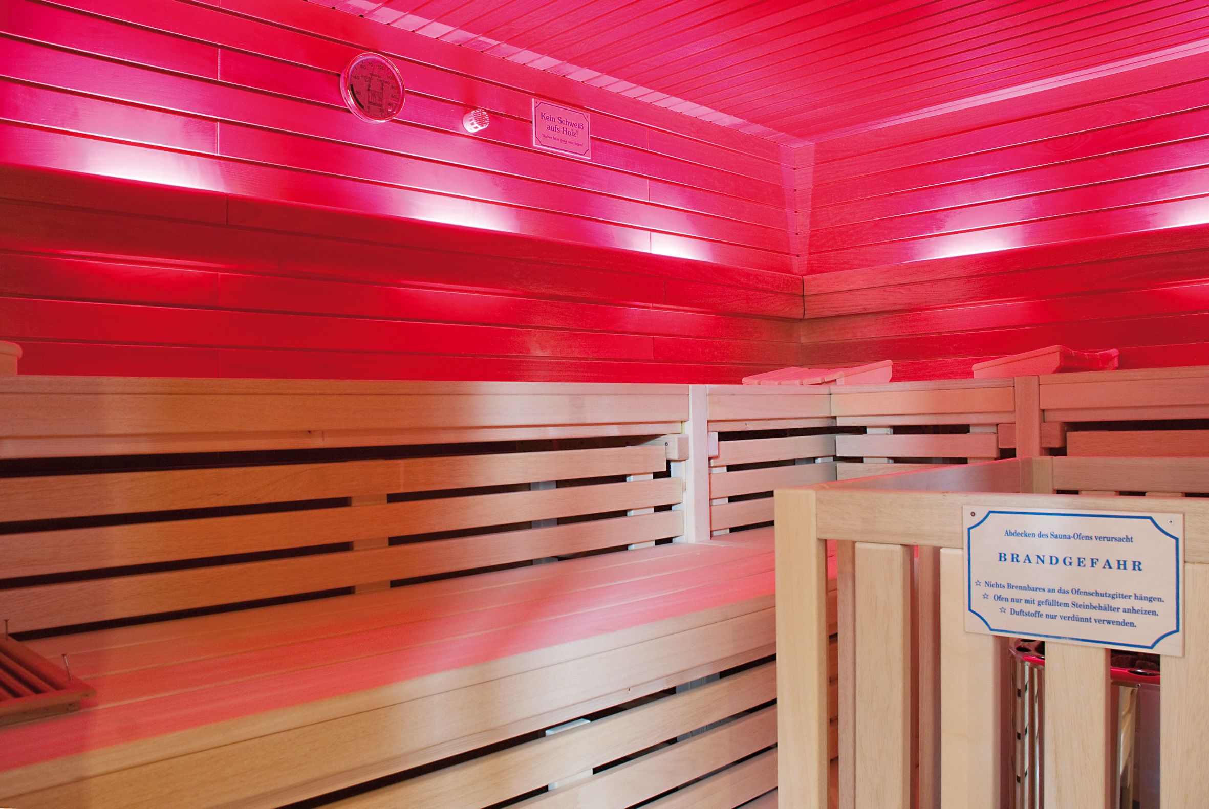 Una sala de sauna con bancos de madera y un letrero que indica que es un baño de marca.