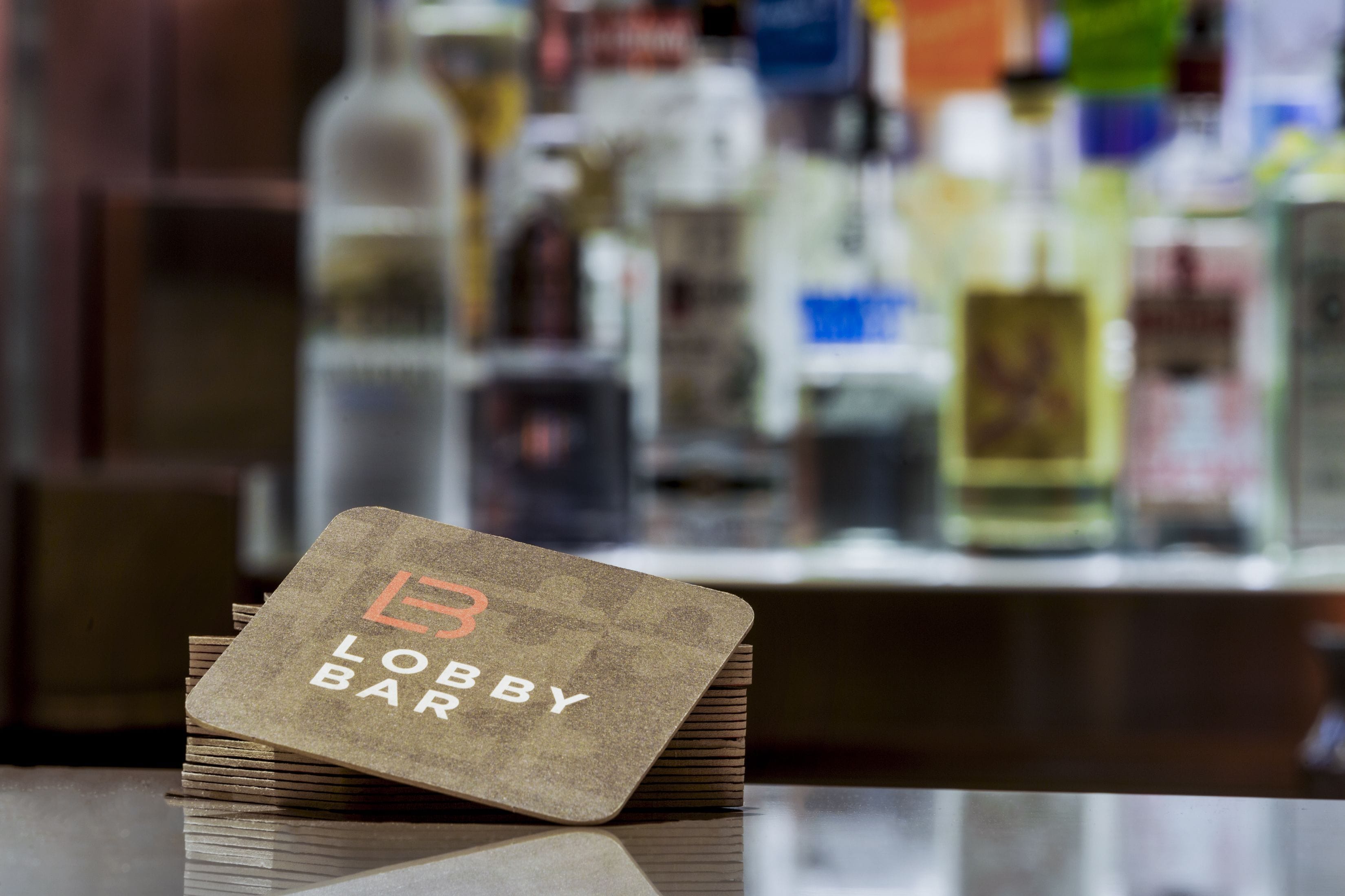 A stack of coasters with the text "Lobby Bar" on a bar counter.