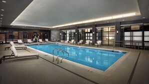Una piscina interior con sillones de descanso y un diseño moderno.
