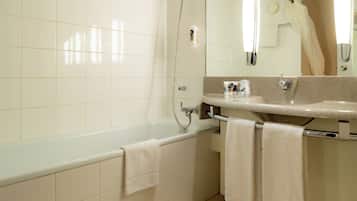 Un baño moderno con bañera, lavamanos y espejo.