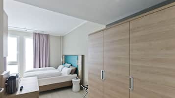 Una habitación de hotel moderna con cama, mesita de noche y armario.