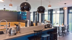 A modern kitchen with a bar area, including a coffee machine, kettle, and bar tools. - elaya hotel stuttgart boeblingen (Boeblingen)