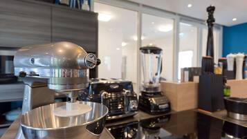 Una cocina con una batidora de pedestal, una licuadora y una cafetera sobre el mostrador.