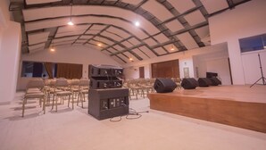 A conference room with a stage, rows of chairs, and audio equipment. - Qallwa Pucallpa (Callería)