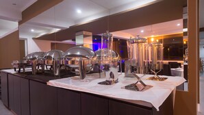 A buffet setup with multiple serving stations, including metal chafing dishes and glassware. - Qallwa Pucallpa (Callería)