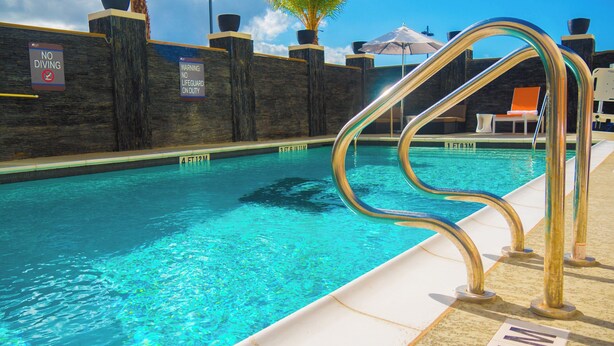 A clear pool with a no diving sign, a lifeguard on duty sign, and a pool depth marker. - Aloft by Marriott Corpus Christi (Corpus Christi)