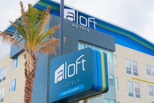 Een hotelsbord met de naam 'aloft hotels' en de slogan 'leef het leven aloft'.