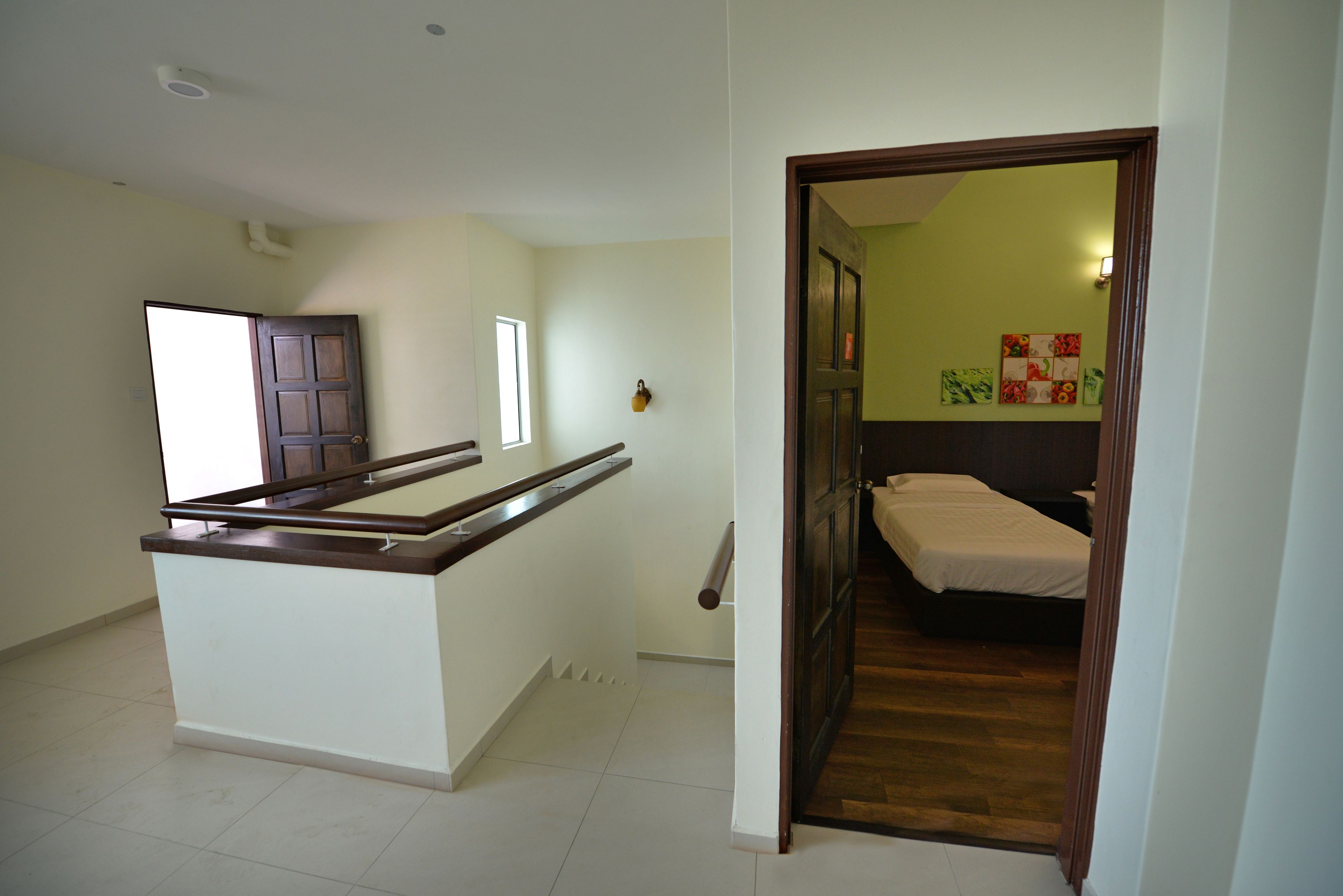 A room with a wooden desk, a bed, and a small window.