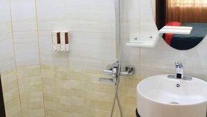 A bathroom with a shower, toilet, and sink.