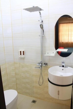 A bathroom with a shower, toilet, and sink.
