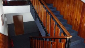 A staircase with wooden steps and a black metal railing. - Hotel ALFONSKA (Benecko)