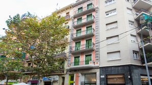 A multi-story building with balconies, a green door, and a visible restaurant sign. - Cosmo Apartaments Marina (Barcelona)