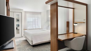 A hotel room with a bed, a desk, a chair, a television, and a mirror. - SpringHill Suites Chicago Southeast/Munster IN (Munster)