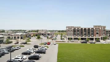 A parking lot with multiple cars and a building with a modern design in the background.