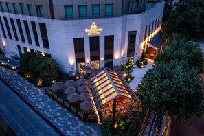 A modern hotel with a prominent entrance, outdoor seating area, and a well-lit facade. - The Sukhothai Shanghai (Shanghai)