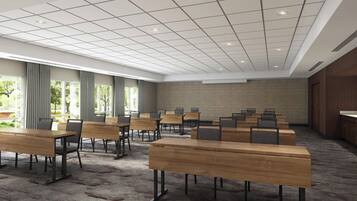 A conference room with multiple tables and chairs, a patterned carpet, and a large window with curtains.