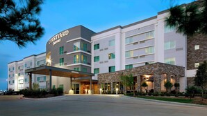 Ein Courtyard Marriott Hotel mit modernem Design, das über mehrere Etagen und einen überdachten Eingang verfügt.