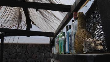 A shelf with various bottles and a rock.