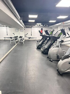A gym with treadmills, stationary bikes, and exercise balls. - Royal Grand Hotel (Monrovia)