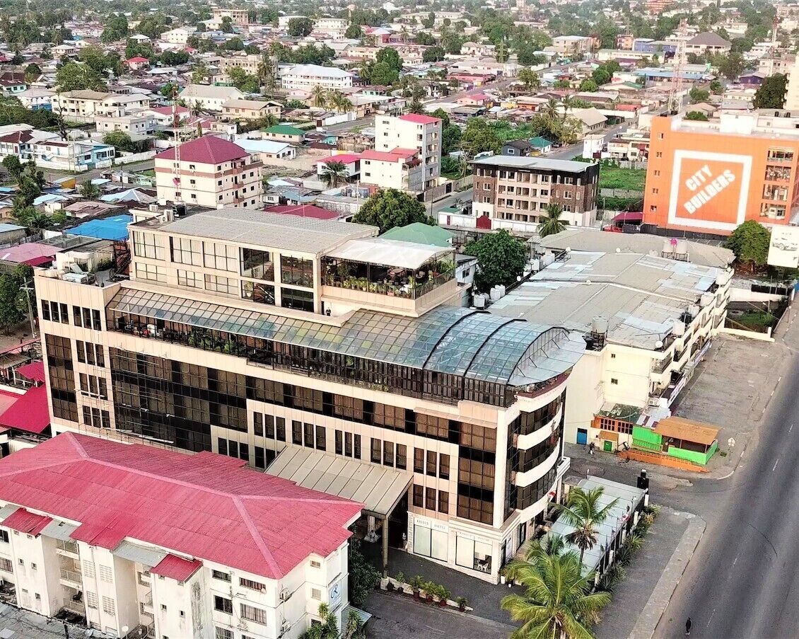 A multi-story building with a flat roof and a large glass facade.