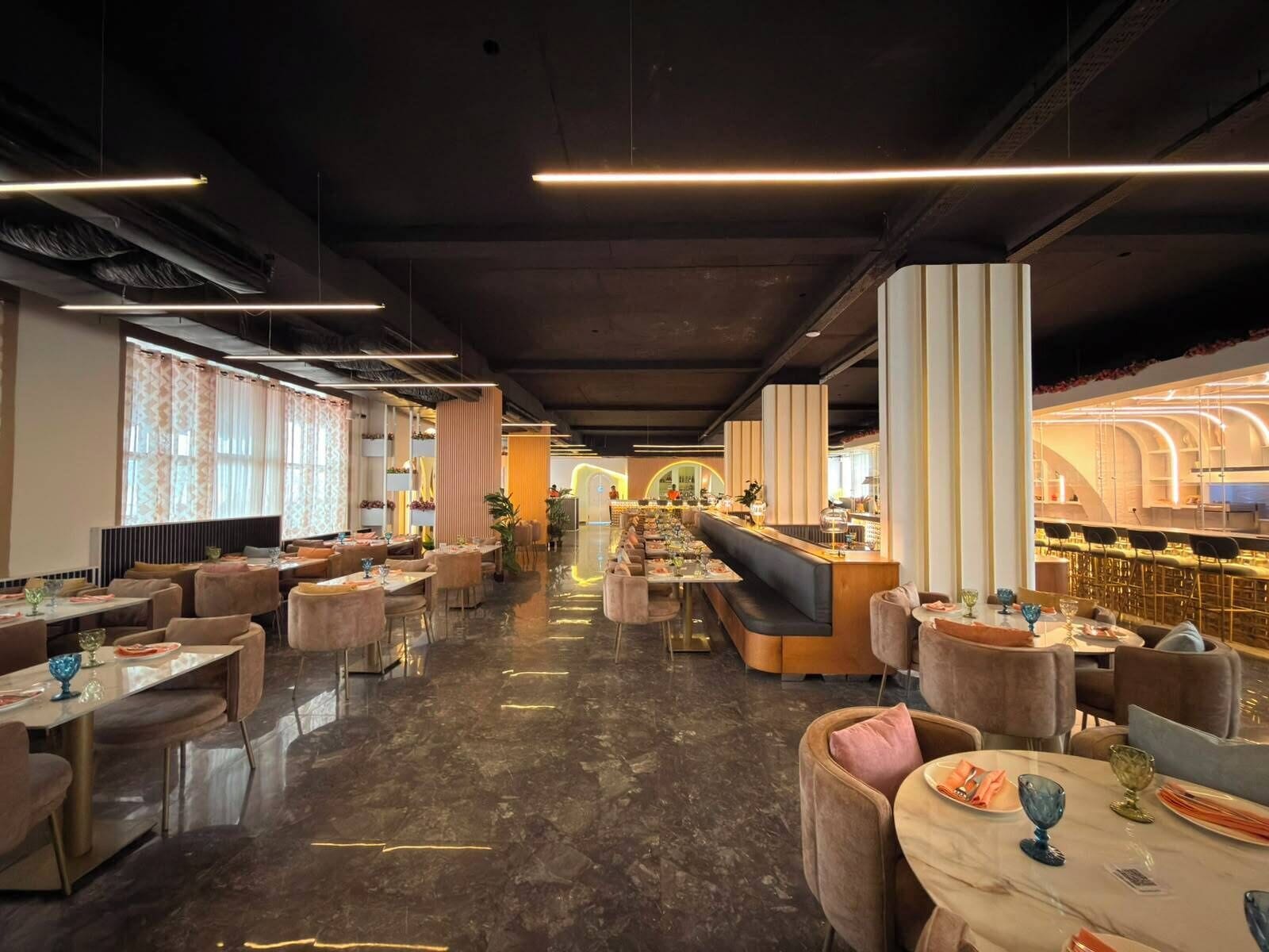 Un interior de restaurante moderno con una barra central, disposiciones para sentarse y un suelo pulido.