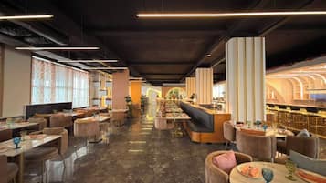 Un interior de restaurante moderno con una barra central, disposiciones para sentarse y un suelo pulido.